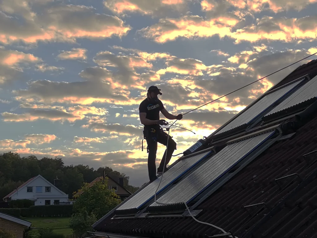 Rengöringsmedel sprutas på ett tak med solnedgång i bakgrunden